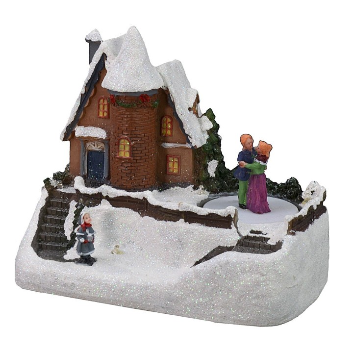 Escenario de casa nevada con pista de patinaje que funciona con