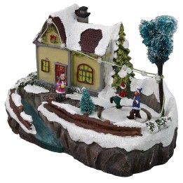 Escenario navideño con casa y pista de patinaje funcionando con