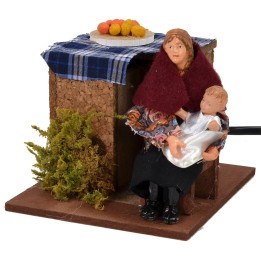 Seated woman in motion cradling the baby 12 cm series