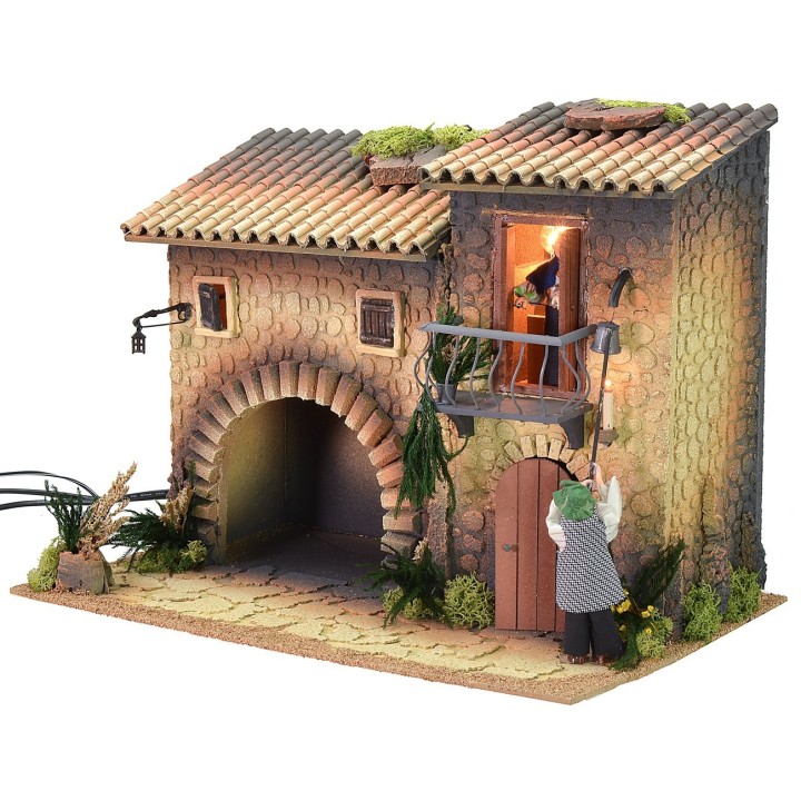 Casa iluminada con farolero de 12 cm en movimiento y mujer que