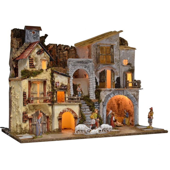 Illuminated nativity scene complete with Landi statues with village and cave