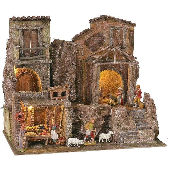 Illuminated nativity scene complete with Landi statues with houses and shops