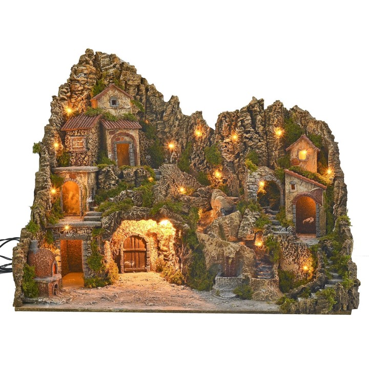 Illuminated nativity scene with cave, fountain, waterfall and fire