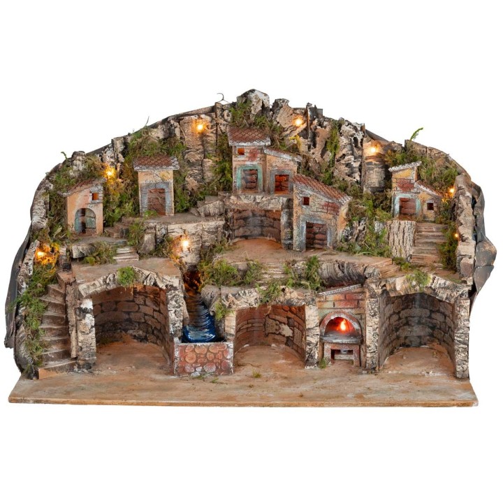 Belén iluminado con cuevas, casitas, arroyo y horno