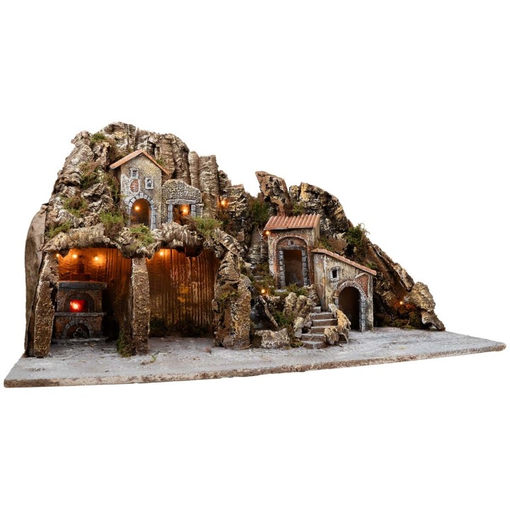 Illuminated nativity scene with oven and small waterfall