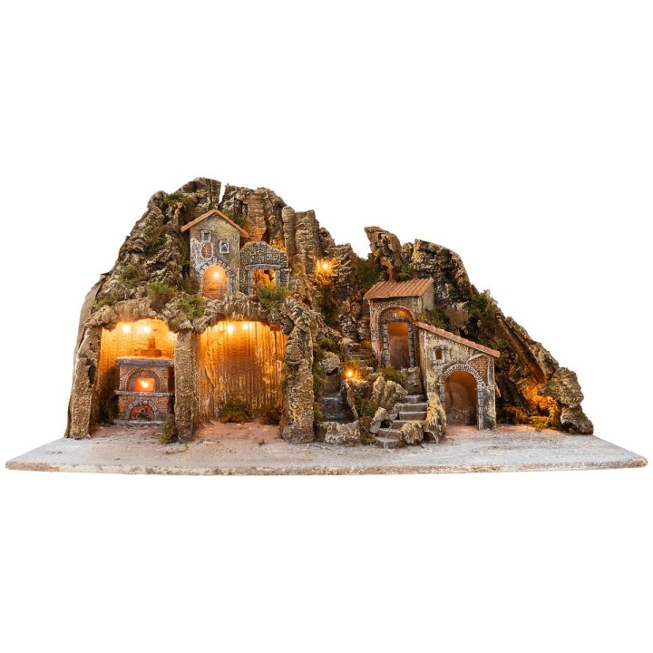 Illuminated nativity scene with oven and small waterfall