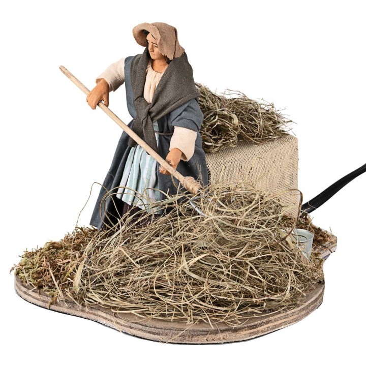 Peasant woman spreading straw in motion 12 cm