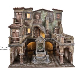 Borgo con piazza illuminata e fontana con pompa funzionante a