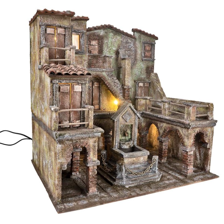 Borgo con piazza illuminata e fontana con pompa funzionante a