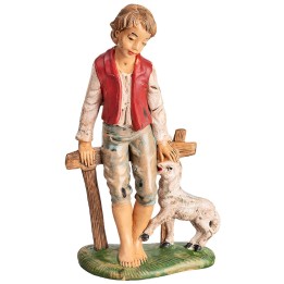 Boy sitting on a fence with a little sheep h 18 cm