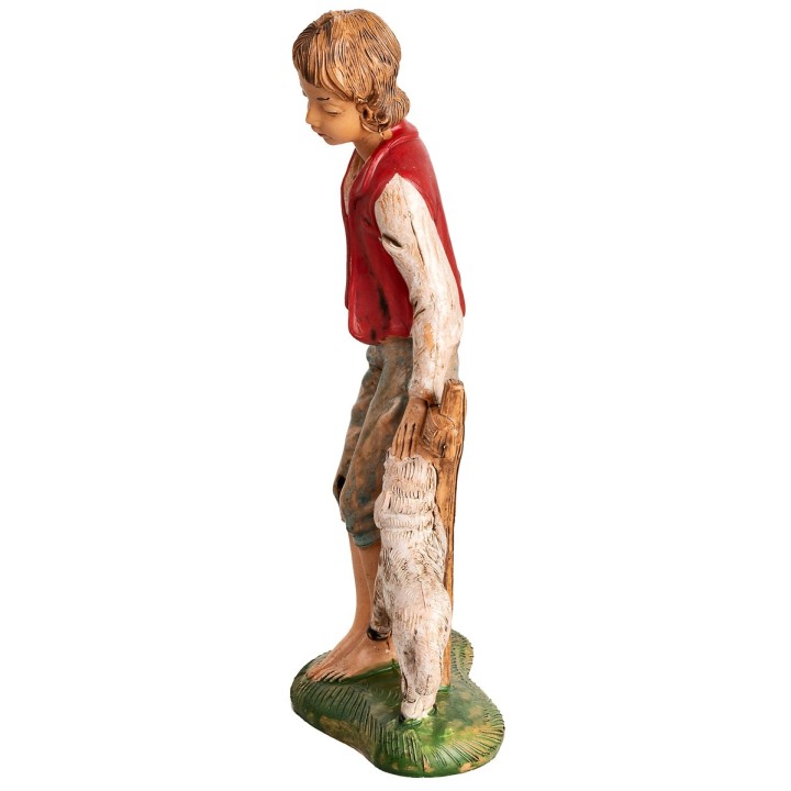 Boy sitting on a fence with a little sheep h 18 cm